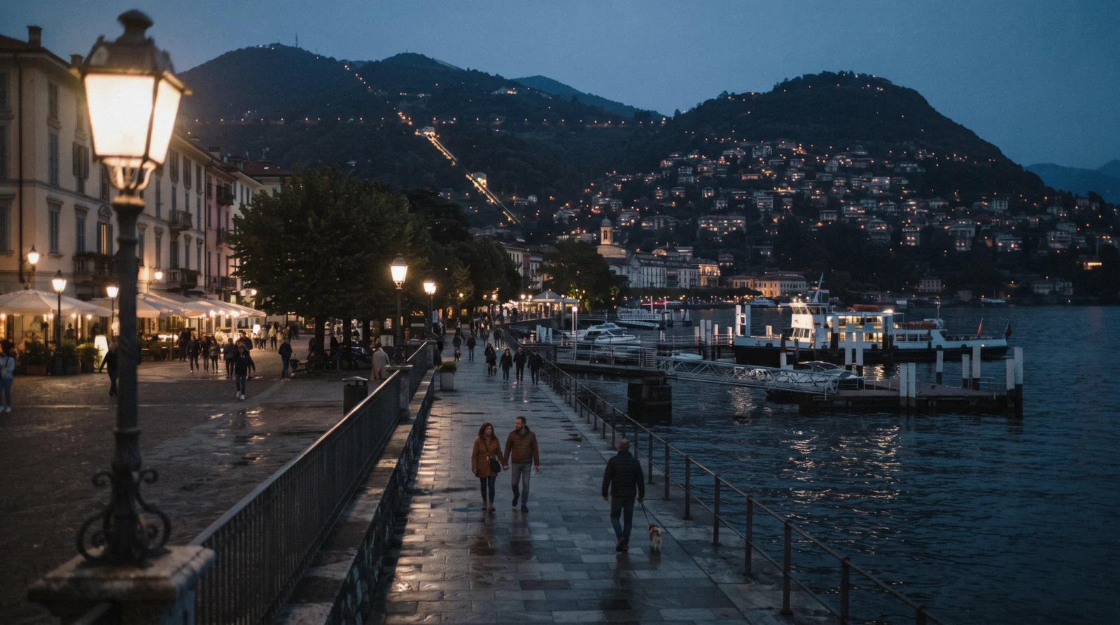 The Como lakefront by Piazza Cavour at dusk with people walking under the lamps, the evening scene behind the question is Como safe