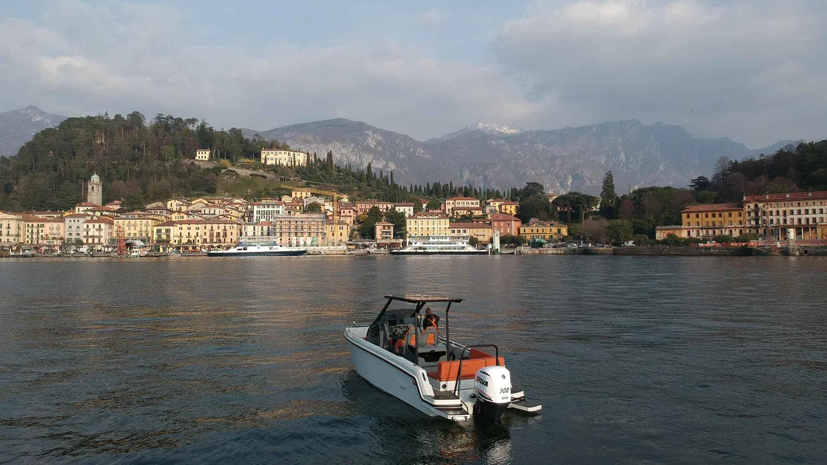 A shared boat docked at Bellagio's lakefront promenade on a Bellagio boat tour from Como, Italy