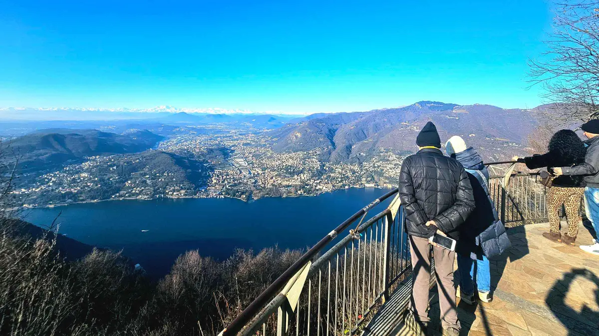 The red Brunate funicular car climbing above Lake Como on a Brunate funicular and boat tour in Como, Italy