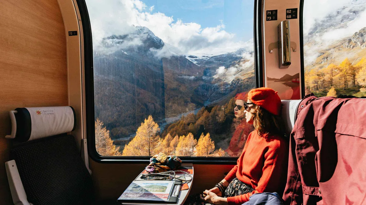 The red Bernina Express panoramic train crossing an Alpine viaduct on a Bernina Express day trip from Como, Italy