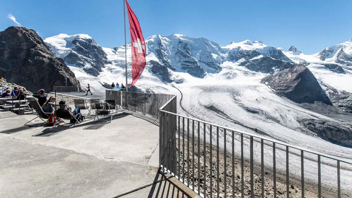 A mountain lunch table with pizzoccheri set against the Diavolezza glacier on a Bernina Express day trip from Como, Italy